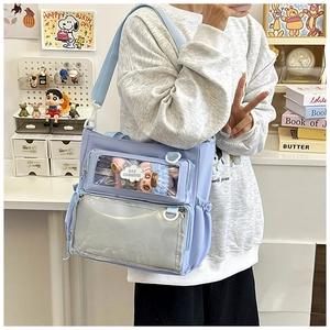 Close-up of lavender ita bag with dual transparent display windows and cute plush charms