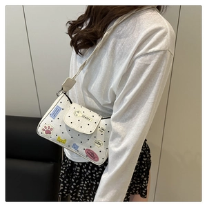 Borsa a tracolla bianca con toppe graffiti colorate e pois indossata da una modella