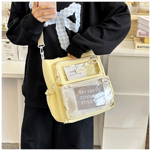Detail of yellow nylon crossbody bag featuring dual transparent PVC zipper pockets