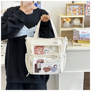 Detailed view of white canvas ita bag with transparent PVC pockets and side drawstring cords