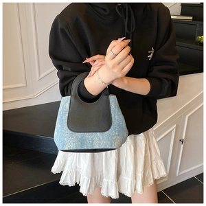 Detail of blue denim patchwork handbag with sequins and black leather handle contrast