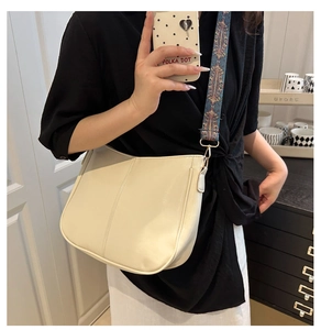 Detail of cream saddle bag with a bohemian ethnic pattern wide shoulder strap