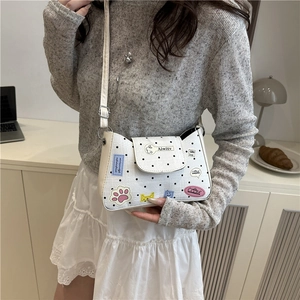 Borsa a tracolla bianca a pois con toppe cartoon indossata da una modella