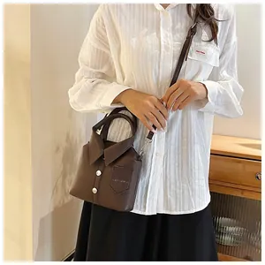 Close-up of creative shirt-shaped crossbody bag in brown pebble grain faux leather