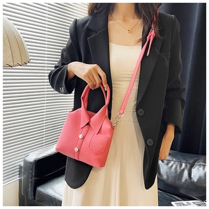 Detail of pink shirt-style handbag showing PU leather texture and button accents