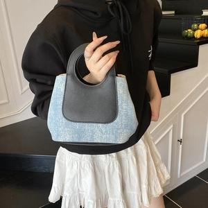 Retro denim and black leather patchwork tote bag with stud details and circular cutout handle