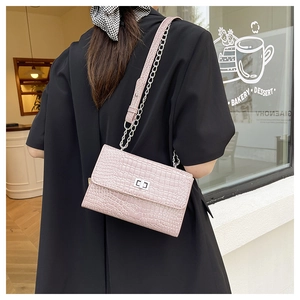 Detailed view of crocodile pattern pink crossbody bag with silver clasp and chain strap