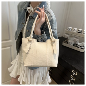 Close-up of white lychee grain leather bucket bag with champagne gold metal hardware