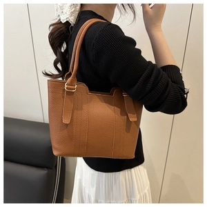 Detailed view of the brown lychee pattern leather texture and golden metal buckle