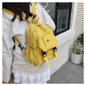 Detailed view of yellow nylon crossbody chest bag with adjustable black buckle closure