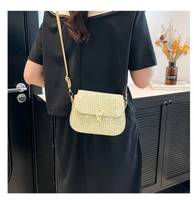Detail of beige woven crossbody bag with white flower embroidery and gold metal lock