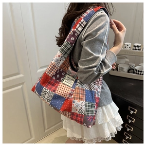 Detail of multi-pattern patchwork canvas tote bag with C'EST LA VIE text embroidery