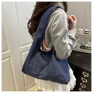 Detail of navy denim tote bag with retro floral lining and outer pocket for casual styling