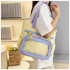 Detail view of the yellow and purple tote bag featuring a large clear window for pins