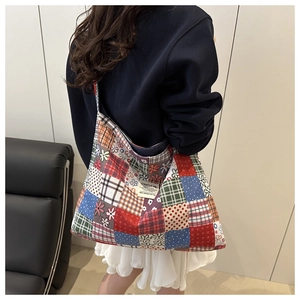 Detail shot of oversized patchwork canvas tote bag featuring mixed floral and plaid patterns