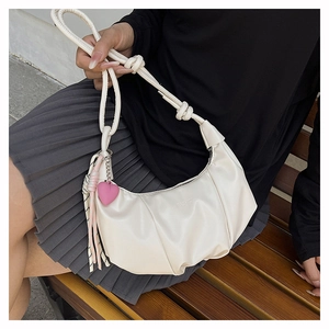 Detail of off-white pleated moon bag with FASHION embossment and heart charm