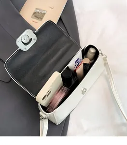 Internal view of a white leather crossbody bag showing capacity for phone and cosmetics