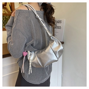 Detailed view of silver metallic crescent bag featuring unique pleated texture and knot strap
