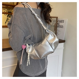 Silver metallic cloud bag with knotted rope shoulder strap and heart pendant detail