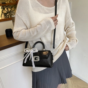Stylish black leather crossbody bag with metal G-buckle and pearl lace bow charm