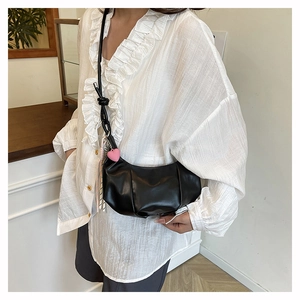 Chic black crescent bag with pleated PU leather detail and pink heart charm accessory