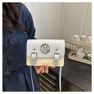 Détail du sac bandoulière bicolore bleu et beige avec boucle logo M métallique