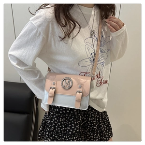 Detail of pink and grey crossbody bag with silver M buckle and dual strap closure