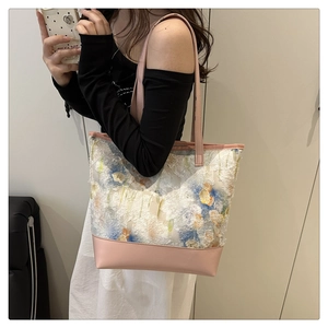 Dettaglio della borsa tote in tela ricamata con trame 3D e manici in ecopelle rosa