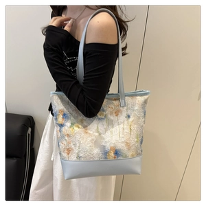 Dettaglio del pizzo floreale 3D e della tracolla in pelle della borsa shopper azzurra