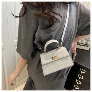 Detail of silver glitter mini handbag with gold twist lock and adjustable shoulder strap
