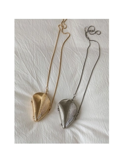 Detail of gold and silver shell-shaped mini bags with radiant textures and snake chains