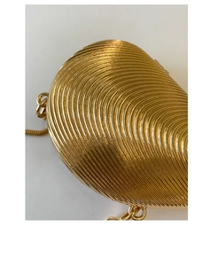 Macro shot of gold shell evening bag featuring radial metallic texture and chain