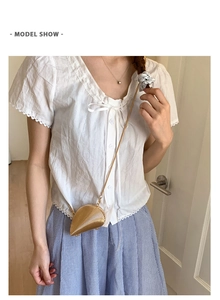 Detailed view of a gold shell-shaped mini bag with fine metal textures and a chain strap