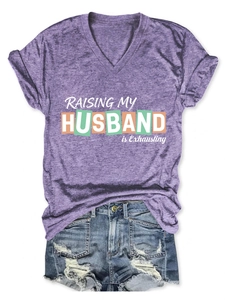 Detail eines lila V-Ausschnitt T-Shirts mit Slogan und Distressed-Denim-Shorts