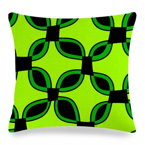Détail d'une housse de coussin carrée avec motif géométrique vert néon et accents noirs