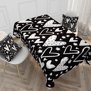 Close-up of Nordic style black tablecloth with white heart patterns and matching pillow