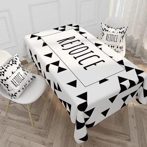 Detail of Nordic style cotton linen tablecloth with black triangle patterns and Rejoice text