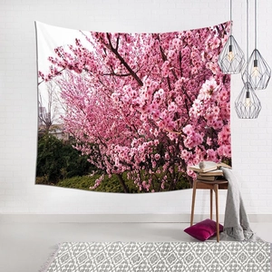 Detail of cherry blossom tapestry hung on a white brick wall in a cozy room setting