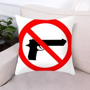 Macro detail of peach skin fabric pillowcase with anti-gun slogan on a gray sofa