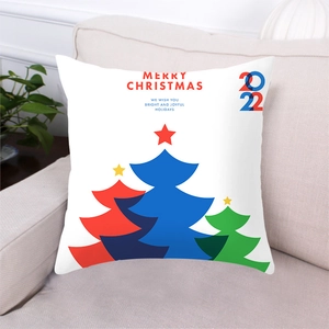 Dettaglio della federa con alberi di Natale colorati posizionata su un divano beige