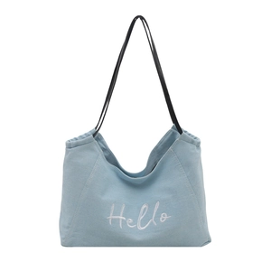 Minimalist light blue canvas tote bag with white Hello embroidery and black shoulder straps