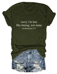 Dettaglio della t-shirt verde scuro con stampa di versetti biblici e pantaloncini denim