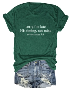 Dettaglio della t-shirt verde scuro con stampa religiosa e shorts in denim invecchiato