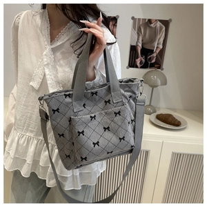 Détail du sac cabas en velours côtelé gris avec broderie nœud et motif matelassé