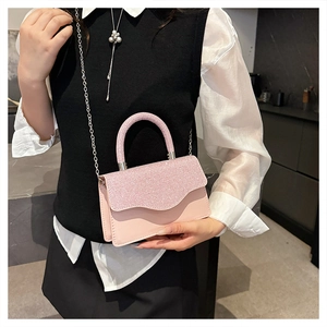 Détail du sac de soirée rose pailleté avec poignée ronde et chaîne argentée sur modèle