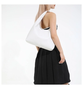 Detailed view of white woven leather hobo bag texture on model shoulder