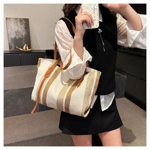 Spacious vertical stripe canvas tote bag with leather straps shown in a lifestyle mirror photo