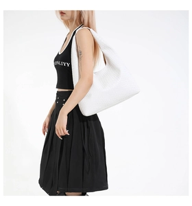 Detail of white woven hobo bag showing the large capacity and leather texture on a model