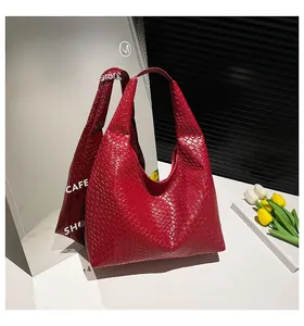 Detail of red hand-woven leather texture on large capacity tote bag with soft structure