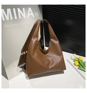 Detail shot of vintage dark brown woven hobo tote bag with intricate leather texture